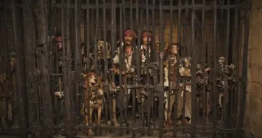 Scene from the Pirates of the Caribbean ride at Disneyland where the pirates in jail are trying to get the key from the dog, except the pirates are robots. The pirates are behind the jail cell bars, the jail cell is locked, the dog is outside of the jail cell and they are trying to tempt the dog is with a USB drive shaped like a bone. The view angle is from 40 degrees to the right of the cell where the dog and the robot pirates can both clearly be seen.