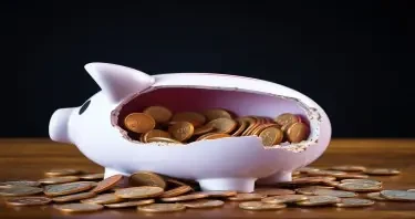 Image: A child’s piggy bank smashed open with coins spilled out