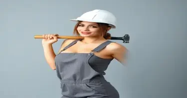 a women wearing grey coveralls down to her side with no shirt on, with medium size boobs, wearing a white hard hat, holding a Sledge Hammer over her shoulder
