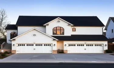 5500 square house, white brick, based in st george utah, black roof, 4 car garge split up with 2, 2 car garages, one of garages in front of house, the other set on the side of the house, two stories