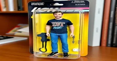Draw an action figure toy of the person in this photo. The figure should be a full figure and displayed in its original blister pack. He always has (a Rush or XTC band t-shirt on, blue jeans, black Skechers, AirPods Pro in his ears, and his iPhone 16 Pro Max).
