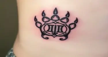 A German Celtic  bear paw tattoo with an alpha symbol on the intwined with a Gemini symbol in the center  placed on the right front pec