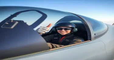 a fighter jet pilot sitting in the cockpit and giving the thunbs up gesture
