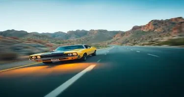 Vintage muscle car driving very fast on an Arizona highway. Motion blur. Low angle. Mid-day lighting.