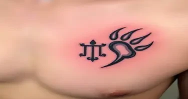 A German Celtic  bear paw tattoo on the right front pec  with a Gemini symbol in the center